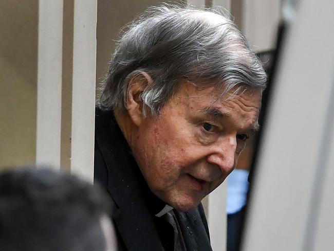 Australian Cardinal George Pell (C) is escorted in handcuffs from the Supreme Court of Victoria in Melbourne on August 21, 2019. - Disgraced Catholic Cardinal George Pell was sent back to jail after an Australian court rejected his landmark appeal against convictions for child sex abuse. (Photo by William WEST / AFP)