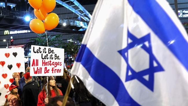 Demonstrators hold placards and wave flags during a protest in Tel Aviv on January 18. Picture: AFP