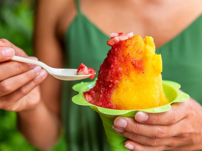 Shave Ice Hawaii local food woman eating hawaiian shaved ice cream treat in Honolulu Waikiki beach, Hawaii, USA.Photo - istockEscape 25 June 2023Hawaii