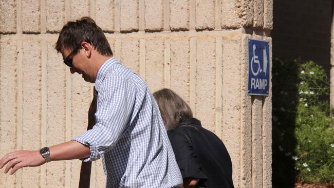 Deborah Lynne Roberts (black shirt, grey hair), 55, enters the Alice Springs Local Court behind her defence lawyer Michael Penman, Tuesday, December 3, 2024. Ms Roberts is charged with the deaths of 71 cattle at the Arid Zone Research Institute in March, 2023. Picture: Gera Kazakov