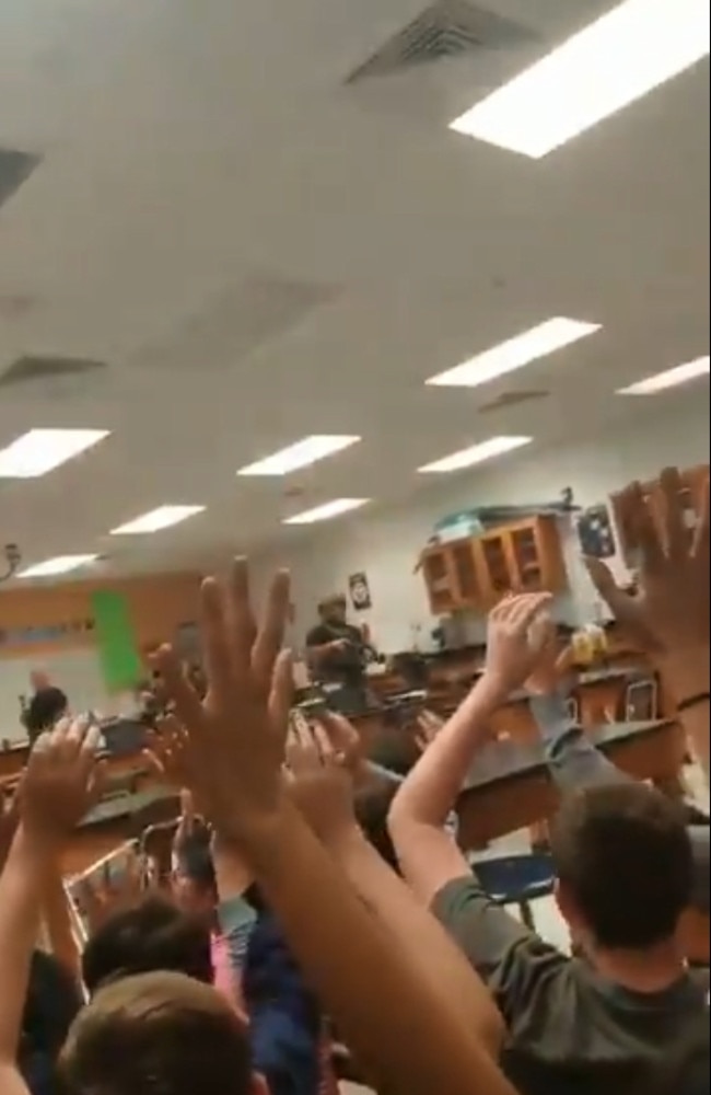 SWAT Team members clear a class room of Marjory Stoneman Douglas High School. Students had to raise their arms as they were led off campus. Picture: Twitter