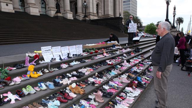 A member of the public expresses their sympathy for victims of forced adoptions outside Parliament House Pictures: AAP Image/Paul Jeffers