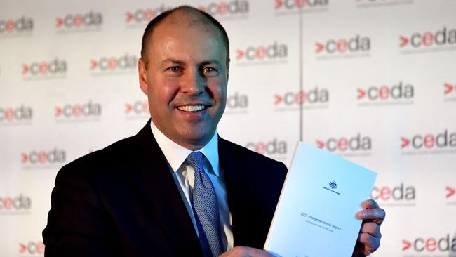 Treasurer Josh Frydenberg holds a copy of the 2021 Intergenerational Report in Melbourne on Monday. Picture: AFP