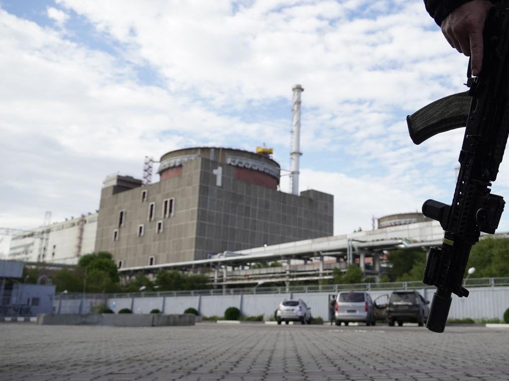 TOPSHOT - This photo taken on September 11, 2022 shows a security person standing in front of the Zaporizhzhia Nuclear Power Plant in Enerhodar (Energodar), Zaporizhzhia Oblast, amid the ongoing Russian military action in Ukraine. - The Zaporizhzhia Nuclear Power Station in southeastern Ukraine is the largest nuclear power plant in Europe and among the 10 largest in the world. (Photo by STRINGER / AFP)