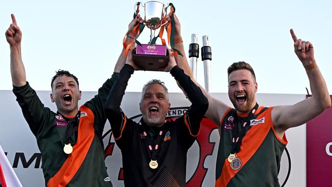 EDFL: Keilor Park’ captains Robert Castello (left) and Daylan Kempster (right) and coach Paul Guicas lift the premiership cup. Picture: Andy Brownbill