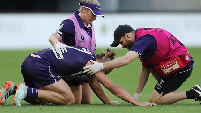 PERTH, AUSTRALIA - MARCH 28: Nat Fyfe of the Dockers is attended to by a trainer after a heavy knock from Sam J. Reid of the Giants during the 2021 AFL Round 02 match between the Fremantle Dockers and the GWS Giants at Optus Stadium on March 28, 2021 in Perth, Australia. (Photo by Will Russell/AFL Photos via Getty Images)