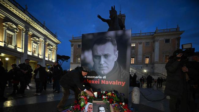 People bring flowers and candles for a vigil in honour of Kremlin's critic Alexei Navalny following is death, on February 19, 2024 in front of Rome's city hall. Picture: Filippo Monteforte/AFP