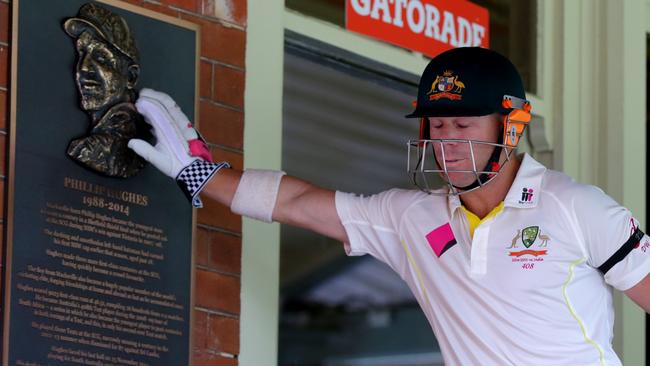 David Warner touches the Phillip Hughes plaque at the SCG. Picture: Gregg Porteous