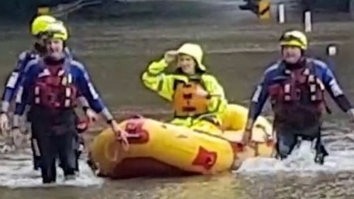 Fire and Rescue Crews guide a paramedic to an eight-year-old boy stranded by floodwater and suffering fever from Covid, at Bucca.