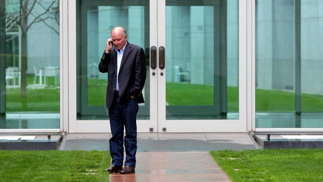 Tony Windsor works the phone during negotiations with the major parties at Parliament House in Canberra yesterday. Picture: Kym Smith