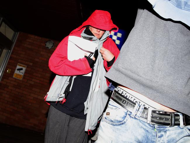 Buttrose and boyfriend Zoran Stopar tried to shield themselves from the waiting media as they left the police station. Picture: Bill Hearne