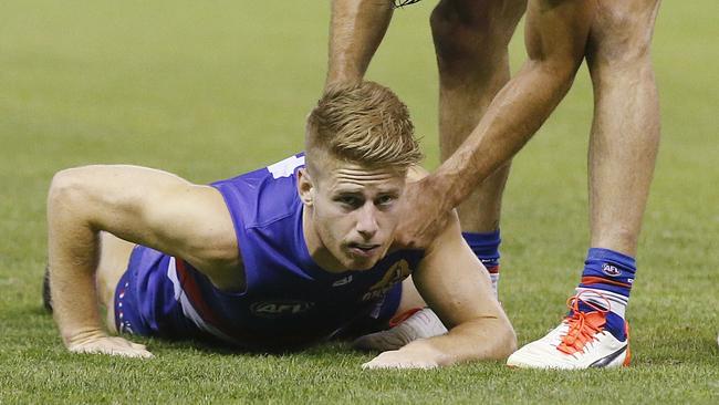 A shaken Lachie Hunter after being tackled high by Lindsay Thomas. Picture: Michael Klein