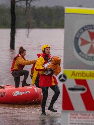 Two NSW Surf Life Savers transported the 10-month-old baby across the fast-flowing flood waters at Wollombi Brook. Picture: Liam Mendes / The Australian