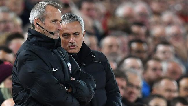 Manchester United's Portuguese manager Jose Mourinho (R) talks to the fourth official.