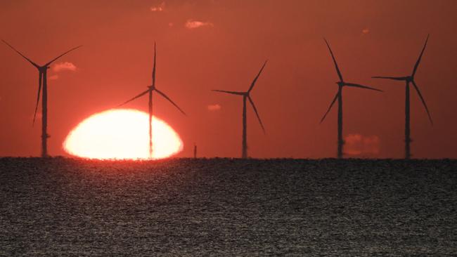 (FILES) In this file photo taken on December 9, 2022, the sun sets over an offshore wind farm, off the coast of the French Western city of Saint-Nazaire. - The European Union Parliament and EU states reached a deal on March 30, 2023 to almost double the share of renewables in the 27-nation bloc's overall energy consumption by 2030. The provisional political agreement seeks to raise the share of renewable energy to 42.5 percent, from 22 percent today, according to a Council of the EU statement, which represents the bloc's governments. (Photo by LOIC VENANCE / AFP)