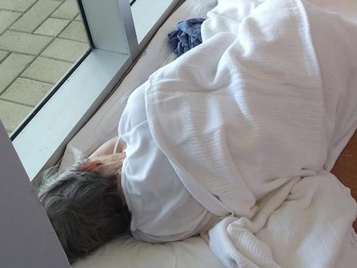 An image of an 84-year-old woman forced to lie on the floor of a hospital has sparked outrage.