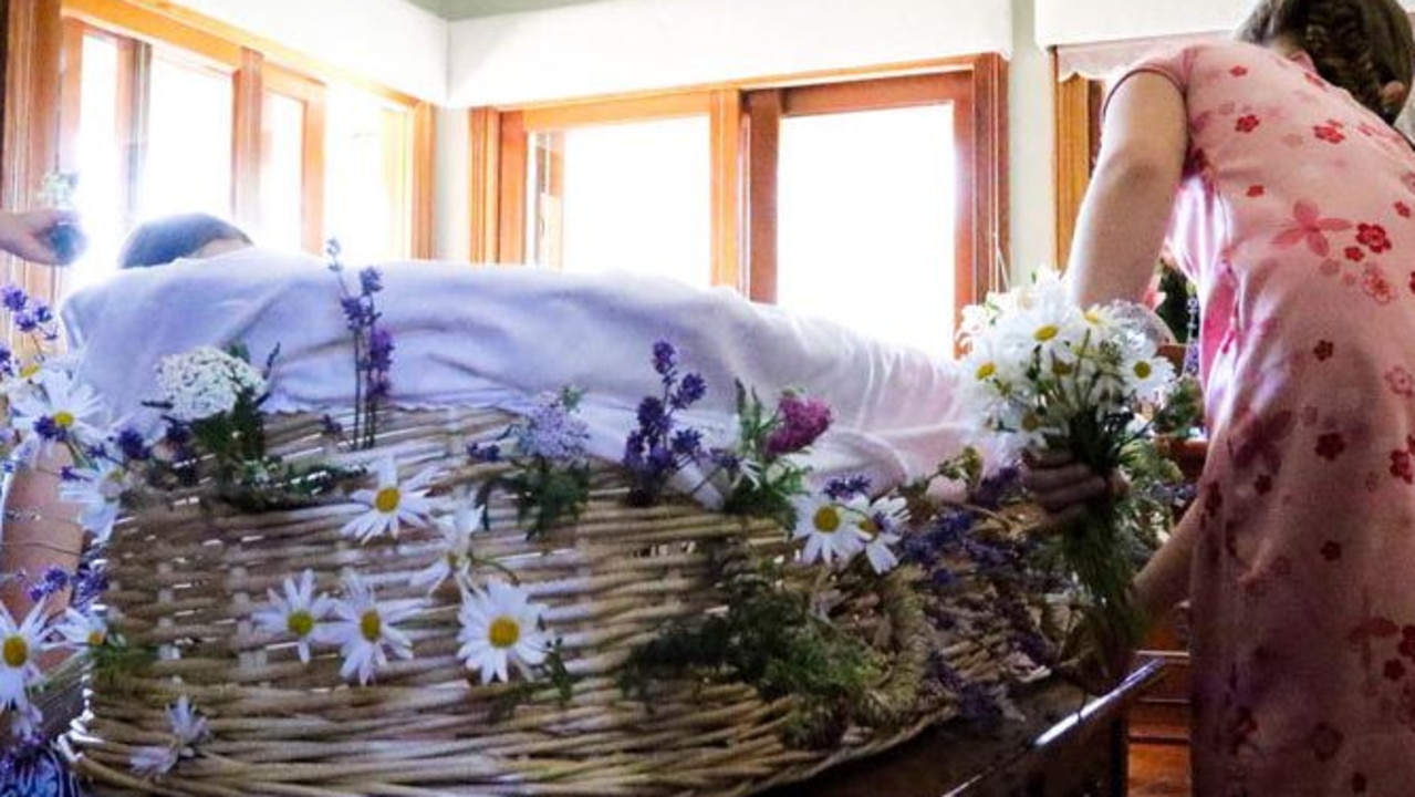 Children decorate their mother’s coffin for a funeral arranged by death doula Lola Rus-Hartland.