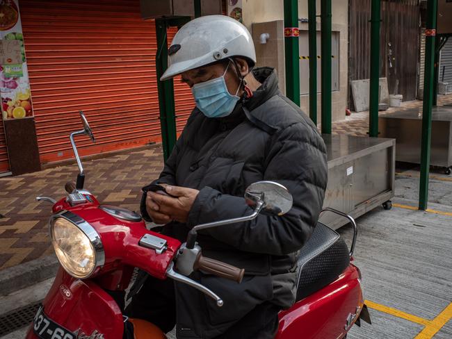 A motorcyclist wearing a face mask looks in Macau, China. The number of cases of a deadly new coronavirus rose to over 4000 in mainland China. Picture: Getty