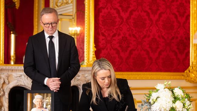 Mr Albanese, and his partner Jodie Haydon sign a book of condolence at Lancaster House. Picture: Getty Images.