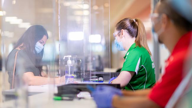 Health Department workers screen interstate arrivals to the NT at Darwin International Airport. Picture: Che Chorley