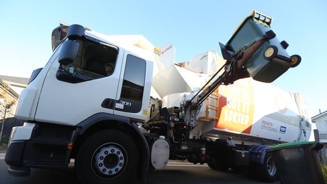 A rubbish truck picks up a yellow bin. Picture: John Grainger