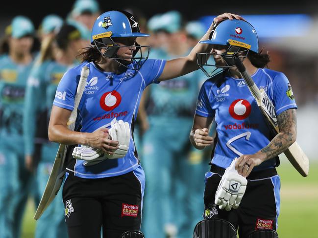 “We’re in this together”: Strikers players Megan Schutt and Sarah Coyte leave the field after being defeated by Brisbane Heat on Saturday, January 5, 2019. This loss meant the team could not make finals. But they are a team that is sticking together. Photo: AAP Image/Dave Acree