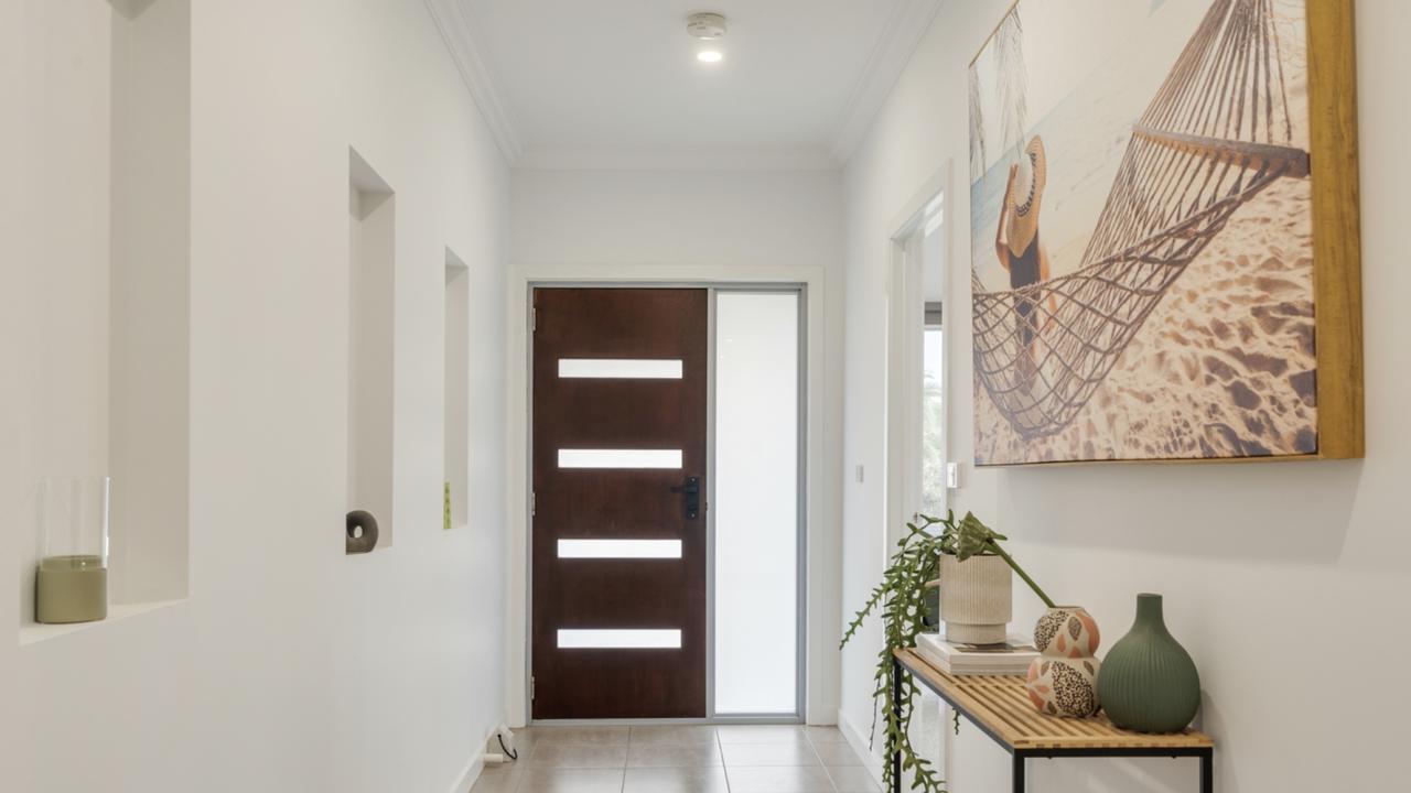 A wide central hallway connects the home’s three bedrooms, including a main suite with private ensuite.