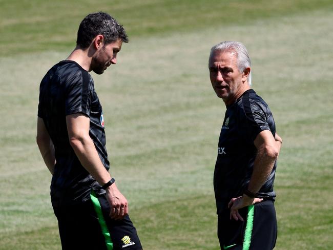 Australia's coach Bert van Marwijk (R) talks to assistant coach Mark van Bommel ahead of the Peru clash. Pic: AFP