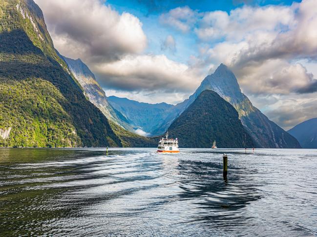 New Zealand. South Island. Tourist boat in the smooth water of the Milford Sound. Fiordland park.The magical nature of the southern hemisphere.Escape 18 February 2024Why I TravelPhoto - iStock