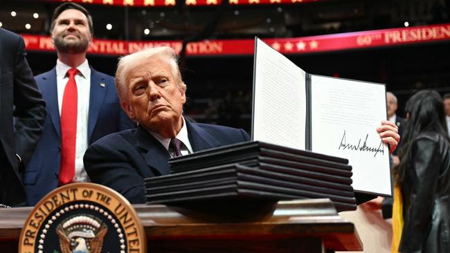 Trump holds an executive order he just signed during the inaugural parade inside Capital One Arena. Picture: Jim Watson / AFP