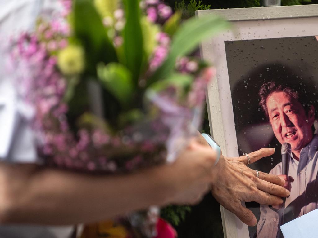 A woman lines up to place flowers at a makeshift memorial outside Yamato-Saidaiji Station, where former Japanese prime minister Shinzo Abe was shot on July 8. Picture: Philip Fomg / AFP