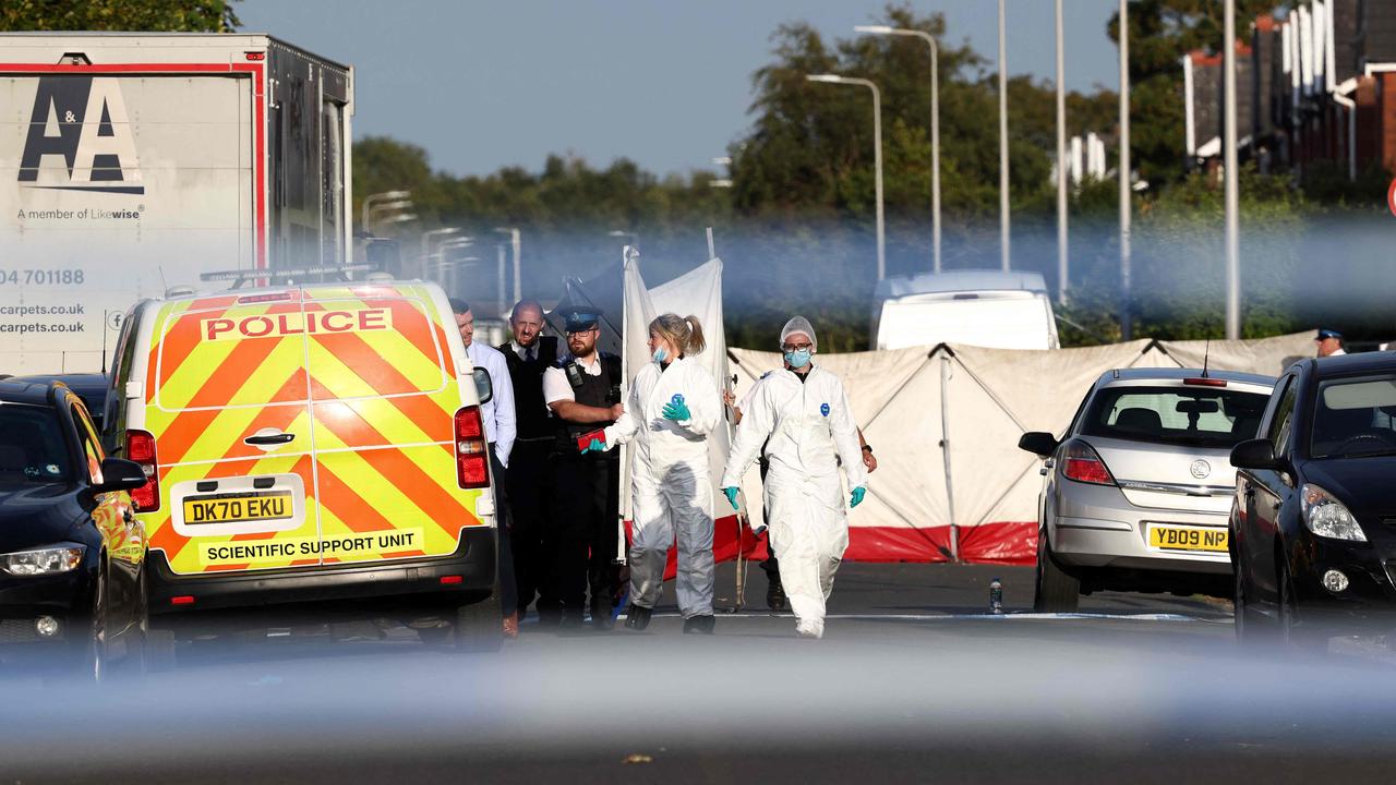 Police officers and forensic personnel put up a fence on Hart Street in Southport, northwest England, on July 29, 2024, following a knife attack. (Photo by Darren Staples / AFP)