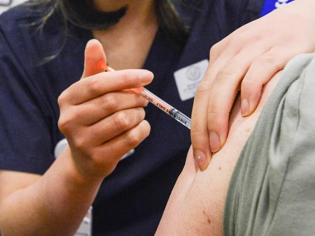 ADELAIDE, AUSTRALIA - NewsWire Photos NOVEMBER 4, 2021: SA Health vaccinator Xuan gives paramedic Sharon Hennessy a Covid booster vaccine at Wayville Vaccination Clinic. Picture: NCA NewsWire/Brenton Edwards