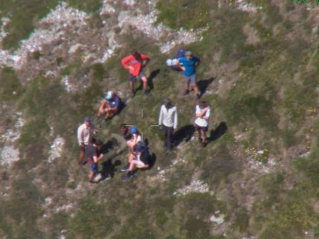 Missing hiker Hadi Nazari (seated) surrounded by hikers who located him off the circuit walk near Blue Lake Picture: 9News