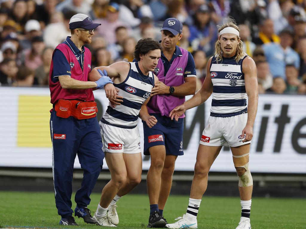 Gryan Miers is helped from the ground by medicos after being cleaned up by Conor Nash. Picture: Michael Klein