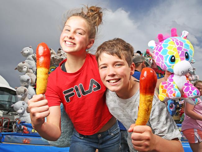 Siblings Beatrice and Ethan enjoying a dagwood dog at the 2019 Royal Hobart Show. Picture: ZAK SIMMONDS