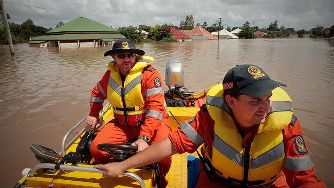 SES flood boat crew Darren McMullen (L) and Jeff Lindsay (R) patrol through the flooded Pelican Street in North Ipswich.