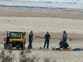 Paramedics and life savers treating a man in his sixties at Kirra Beach on Saturday morning after the skydiver broke his ankle upon landing. Picture: Facebook