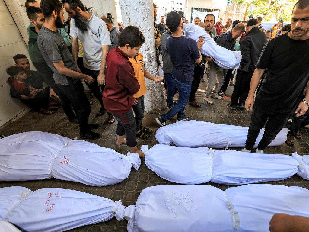 People gather by the bodies of victims who died in an overnight blast at the Ahli Arab hospital in central Gaza on October 18. Picture: AFP