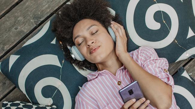 An African woman is at home, listening to music and relaxing, high angle view