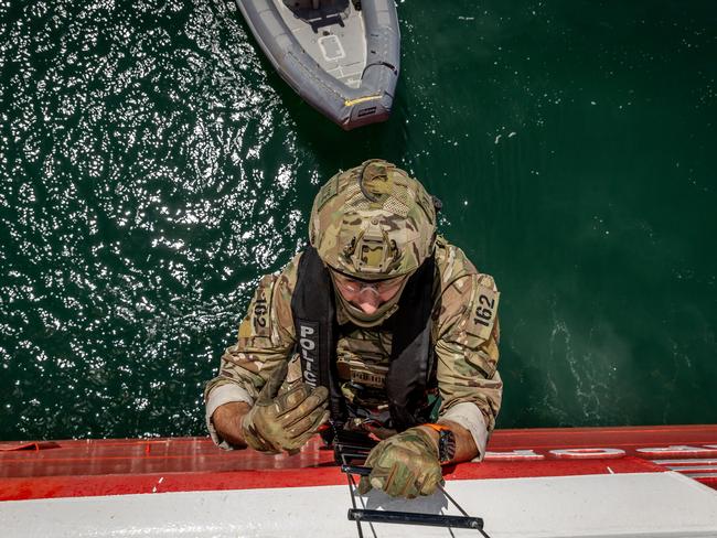 Officers arrive in speed boats and scale the side of the ship to respond to a mock emergency on the Spirit of Tasmania. Picture: Jake Nowakowski