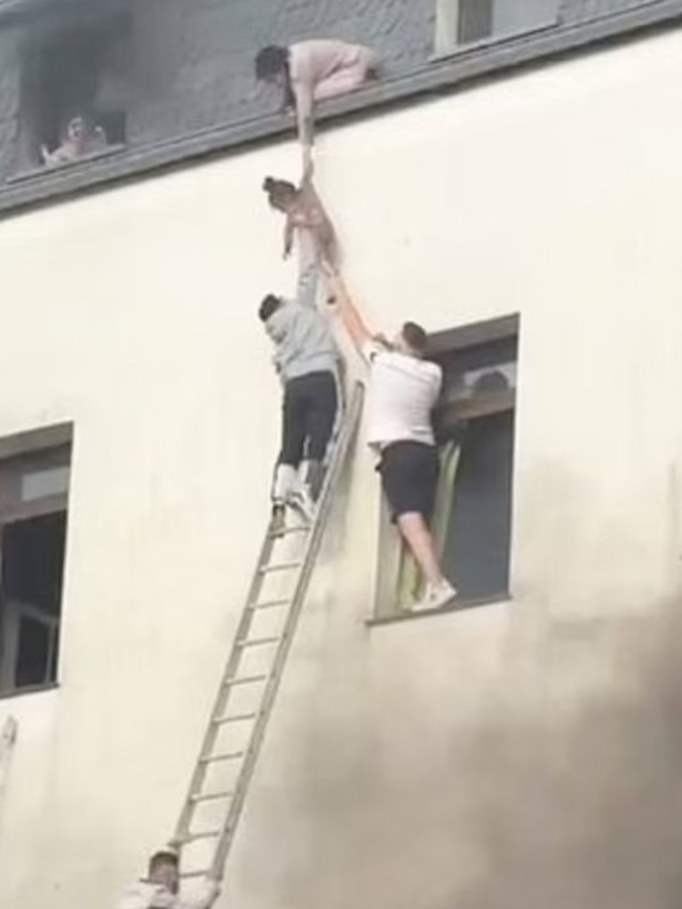 A photo shared on social media shows multiple people rescuing a small child from a building. Picture: X