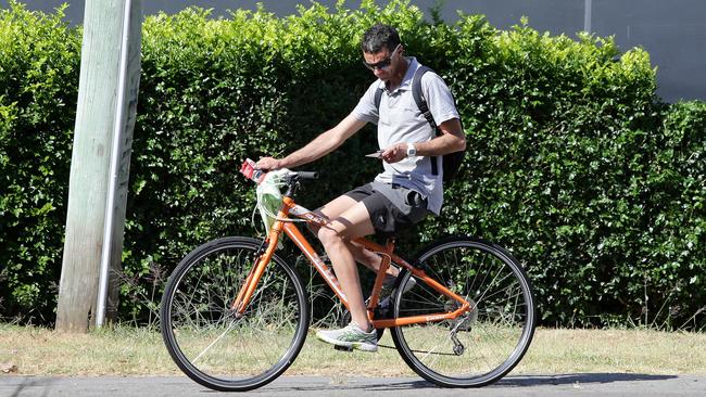 A cyclist rides along with no helmet on his mobile phone. Picture: Peter Lorimer.