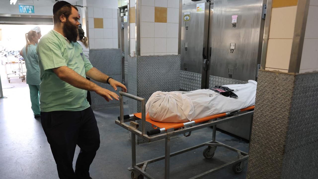 An employee prepares to move a body, ahead of being identified. Picture: AFP