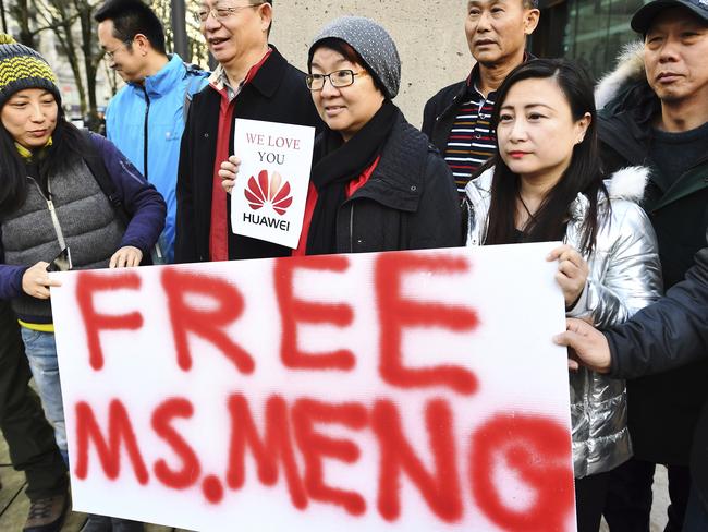 People hold a sign at a Vancouver, British Columbia courthouse prior to the bail hearing for Meng Wanzhou, Huawei's chief financial officer on Monday, December 10, 2018. (Jonathan Hayward/The Canadian Press via AP)