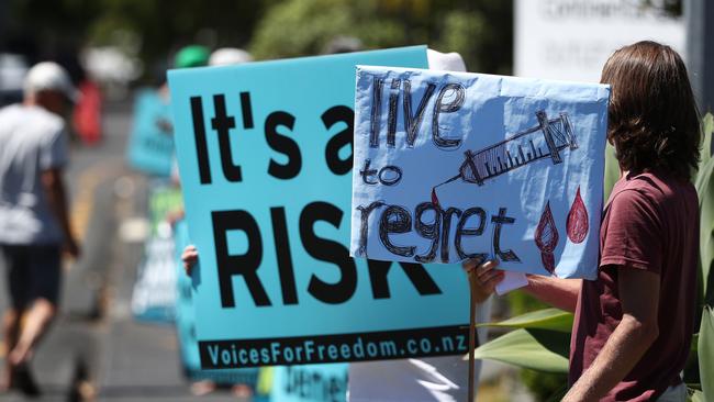 Anti-vaccination protesters line the street outside an Auckland drive-through vaccination centre. Picture: Fiona Goodall/Getty Images