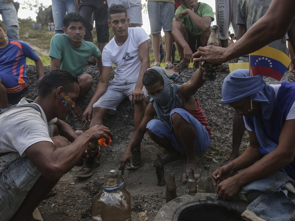 Venezuelan demonstrators prepare gasoline bombs during a protest at the border between Brazil and Venezuela, in Pacaraima, Roraima state, Brazil. Picture: AP