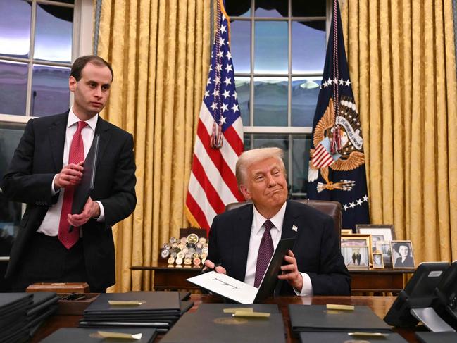 US President Donald Trump signs executive orders in the Oval Office of the WHite House in Washington, DC, on January 20, 2025. (Photo by Jim WATSON / POOL / AFP)