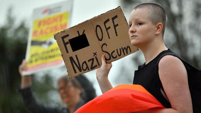 A protester waves a placard at a Milo Yiannopoulos speaking engagement.