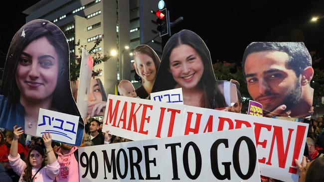 Demonstrators raise placards and cutout pictures of hostages held captive in Gaza since the October 7, 2023 attack. Picture: AFP